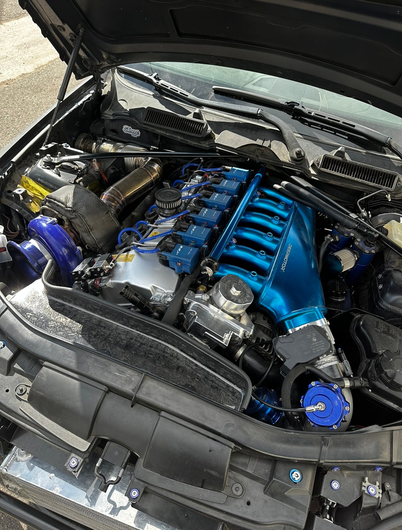 Engine bay showcasing custom European tuning modifications for BMW, Audi, Mercedes, McLaren, Lamborghini, and Porsche cars.